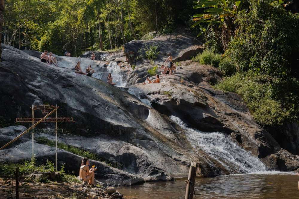 Les touristes s'amusent à la cascade de Mo Paeng
